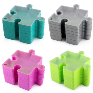 Stackable puzzle sorting trays in four vibrant colors with interlocking jigsaw design