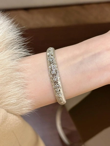Detailed close-up of a silver zircon-studded vintage镂空pattern bracelet on a wrist