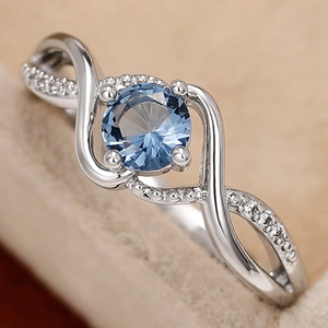 Elegant wavy silver ring with a round blue gemstone and pavé zircon infinity band