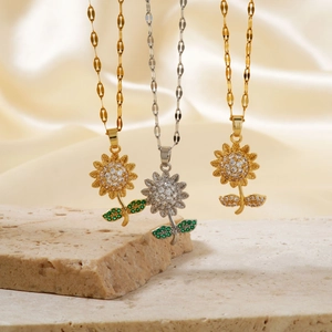Elegant gold and silver sunflower necklaces with zircons on stone and silk background