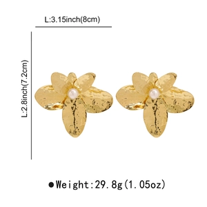 Detail of oversized gold flower earrings with pearl center and 8cm length dimensions