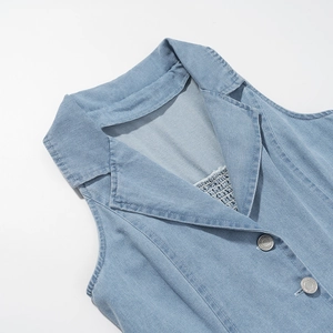Detailansicht eines hellblauen Jeanskleid-Ausschnitts mit polierten Qualitätsknöpfen