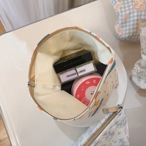 Overhead view showing the spacious interior of a blue floral canvas makeup bag