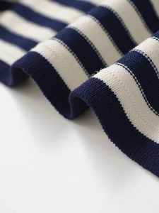 Détail rapproché de la texture du tricot à rayures bleues et blanches pour femme