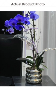 Detail of blue orchid artificial plant in wavy silver metallic pot with glitter stems