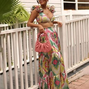 Detail of high-waisted tiered maxi skirt and ruffled bikini top with vibrant abstract print