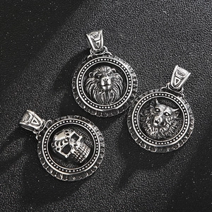 Detail of vintage stainless steel lion, wolf, and skull pendants with antique silver finish