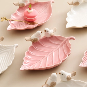 Leaf-shaped ceramic jewelry dish with bird figures in pink and white set
