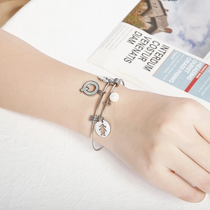 Adjustable silver steel bracelet with 'Q' charm, girl pendant and a single pearl
