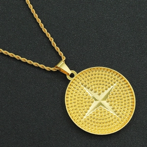 Macro view of gold round pendant with geometric textures and twisted chain detail