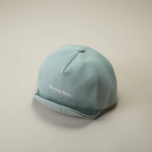 Close-up of mint green cotton baby cap with Bonita Baby and smile embroidery