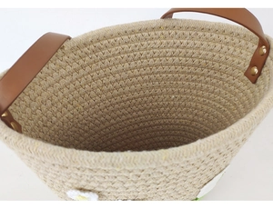 Close-up of beige woven cotton rope basket with brown PU leather handles and metal rivets