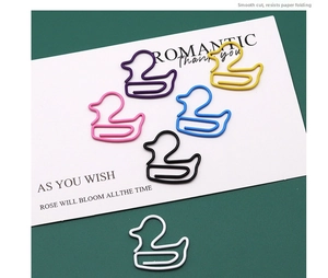 Macro shot of colorful duck-shaped paper clips in purple yellow pink blue and white