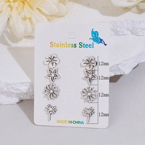Set of four minimalist silver stainless steel flower stud earrings for women on white stones