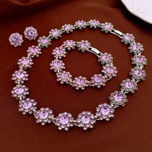 Close-up of vintage flower jewelry set with purple gemstones and crystals on silk