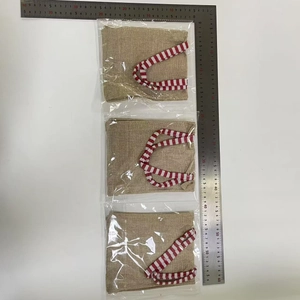Detailed view of three burlap gnome gift bags with red striped handles and size measurement