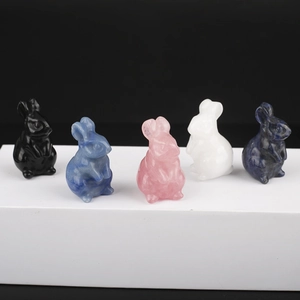 Detailed row of five hand-carved natural crystal rabbits in various vibrant colors