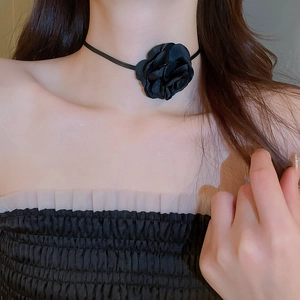 Close-up of a French retro black rose choker necklace worn on a model with lace detail