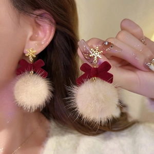 Detail of Christmas earrings with red velvet bow, gold snowflake and plush pompom ball