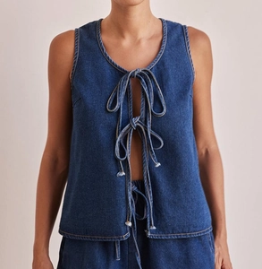 Detail of dark blue denim sleeveless top with three-tie front closure and washed finish