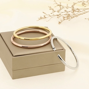 Polished 4mm stainless steel bangles in gold, silver and rose gold on a jewelry box