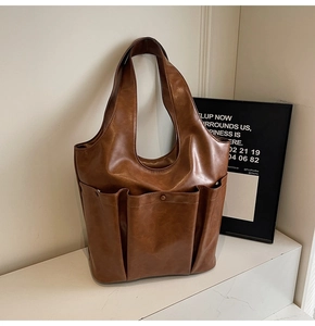 Detailed view of a brown vintage tote bag with functional multi-pockets and glossy PU leather