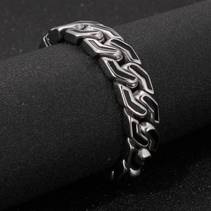 Macro detail of men's stainless steel bracelet with black geometric arrow link patterns