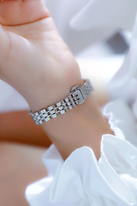 Close-up of a luxury silver chain watch strap on a wrist with polished metal links