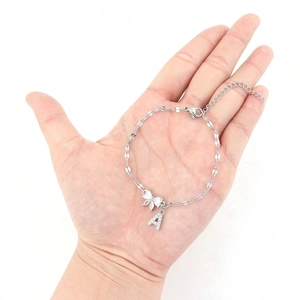 Elegant silver bow bracelet with crystal A letter pendant shown on a female model wrist