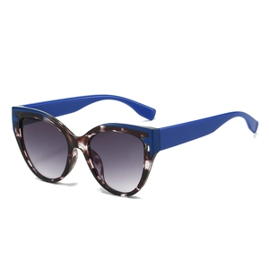 Fashion cat eye sunglasses with tortoise frame and dark blue temples on white backdrop