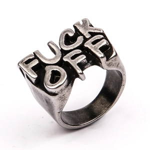 Macro detail of vintage silver steel ring with bold FUCK OFF engraved letter cutout