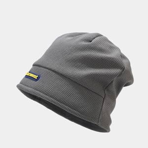 Close-up of dark grey slouchy beanie with Garment logo label and waffle knit texture