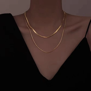 Close-up of double-layer gold snake chain and delicate round link necklace set
