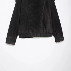 Women's black faux suede biker jacket with elastic hem and button closure on white wall