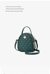Détail du mini sac matelassé vert foncé avec boucle trèfle dorée et double fermeture éclair
