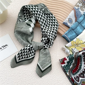 Elegant geometric silk scarf for women with various floral patterns on wooden background