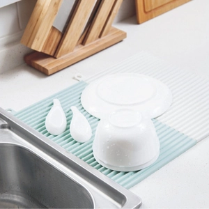 Dual-color striped silicone drying mat with dishes on marble kitchen countertop