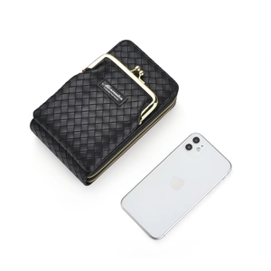 Sac bandoulière noir tressé présenté avec un smartphone pour comparer la taille réelle