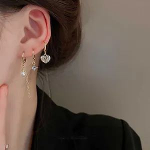 Close-up of gold-plated earring set featuring heart-shaped zircon and a hanging pearl drop