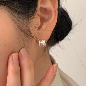 Detailed view of sterling silver layered hoop earrings on a model showing metal texture