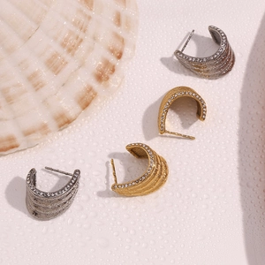 Macro view of gold and silver wave earrings with micro-set rhinestones and water drops