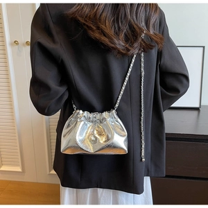 Close-up of a silver pleated cloud bag with a pearl charm and elegant chain strap