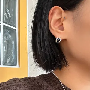 Detail view of 925 sterling silver ear cuff set featuring a black oval gemstone on a model