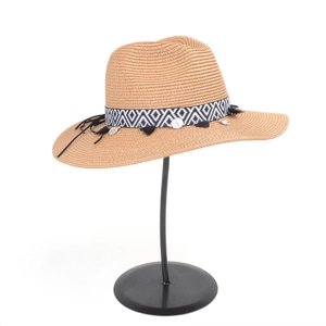 Detail of bohemian wide-brim straw hat with geometric woven band and black tassels