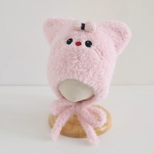 Detailed view of pink plush baby hat with cat ears, soft faux fur and bow ties