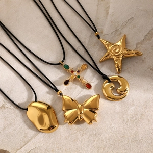 Five gold pendant necklaces with butterfly, starfish and cross charms on black cords