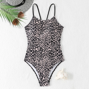 Flachbild eines Leoparden-Badeanzugs mit überkreuzten Trägern und Strand-Accessoires