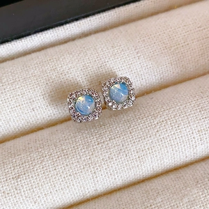 Vue détaillée des boucles d'oreilles carrées avec pierre bleue et monture en argent