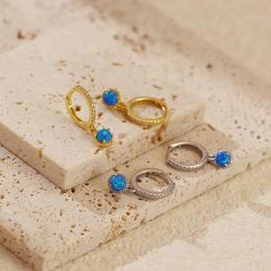 Detailed close-up of S925 silver ear hoops with blue opal stones and sparkling zirconias