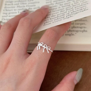 Close-up of triple bow sterling silver open ring on hand with elegant aesthetic